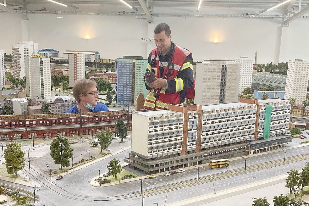 Der stellvertretende Ortsbrandmeister Alexander Beitelmann (stehend) kontrollierte mit einer Wärmebildkamera den Bereich. Mitarbeiter des Miniaturlandes hatten das Feuer bereits gelöscht. Foto: Feuerwehr