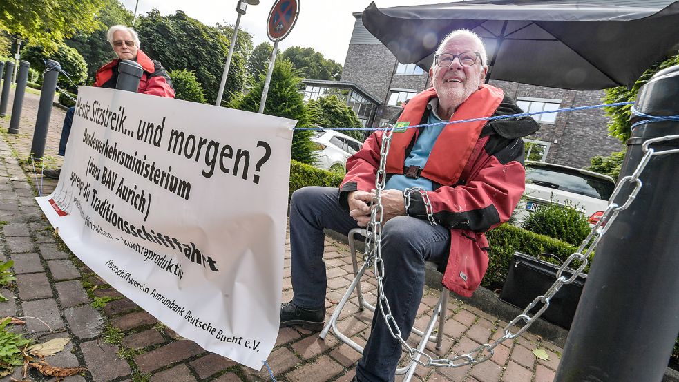 Vor dem Gebäude der Bundesanstalt für Verwaltungsdienstleistungen am Schlossplatz legten sich Vereinschef Heinz-Günther Buß (rechts) und Schatzmeister Heinz Salewski vom Feuerschiffsverein in Ketten. Foto: Ortgies