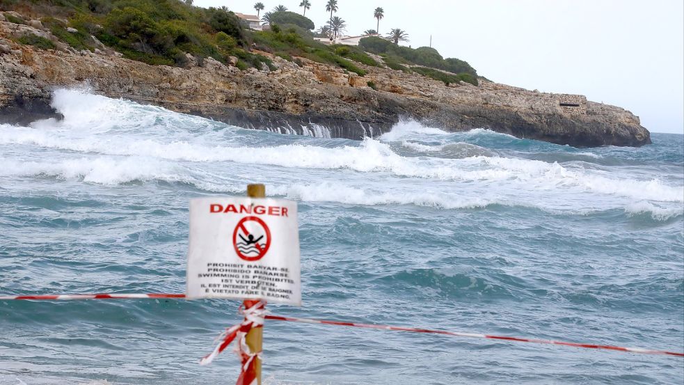 Ein Schild verbietet das Schwimmen am Strand von Cala Mendia in Manacor auf Mallorca. Foto: Clara Margais/dpa