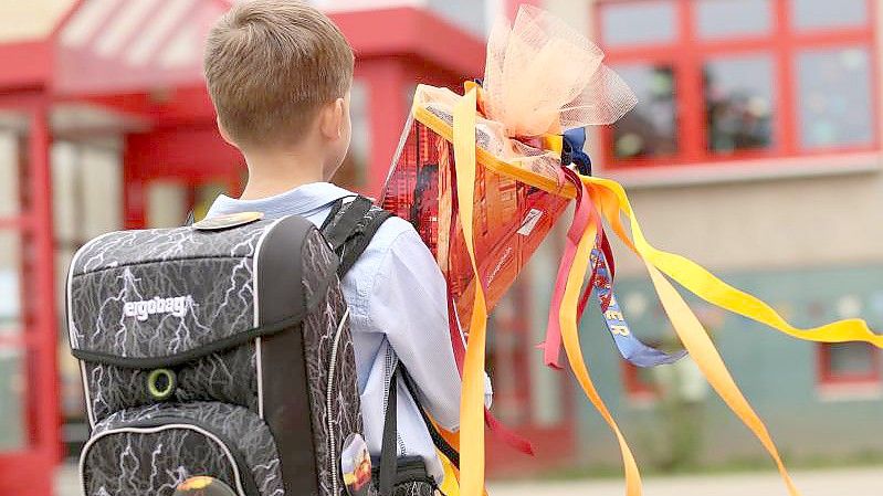 Ein Erstklässler wird mit seiner Schultüte in Sachsen-Anhalt eingeschult. Der Rechtsanspruch auf Ganztag in der Grundschule ist beschlossene Sache. Foto: Matthias Bein/dpa-Zentralbild/ZB