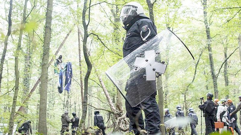 Polizisten stehen im September 2018 vor einer Barrikade im Hambacher Forst, in der sich eine Aktivistin festgebunden hat. Foto: Marcel Kusch/dpa