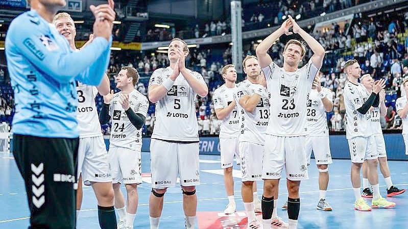 Die Spieler des THW Kiel feiern den Sieg gegen HBW Balingen-Weilstetten. Foto: Axel Heimken/dpa