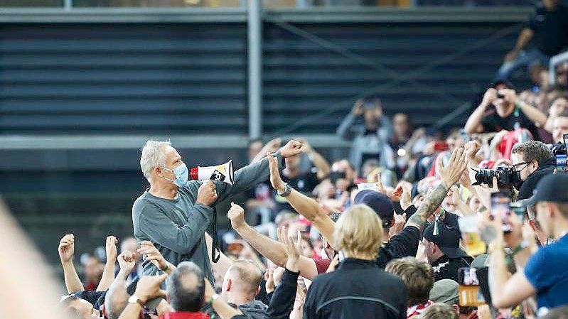 Freiburgs Trainer Christian Streich verabschiedet sich nach dem 3:0-Erfolg gemeinsam mit den Fans vom altehrwürdigen Dreisamstadion. Foto: Philipp von Ditfurth/dpa