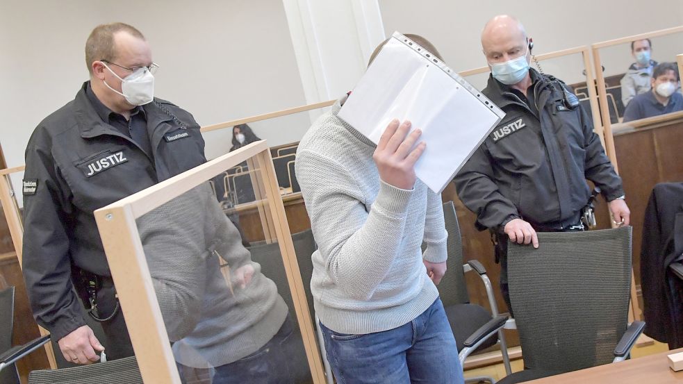 Dieses Foto entstand beim ersten Prozesstag. Hinter einem Schriftstück verbarg der 22-jährige Angeklagte sein Gesicht. Foto: Archiv/Ortgies