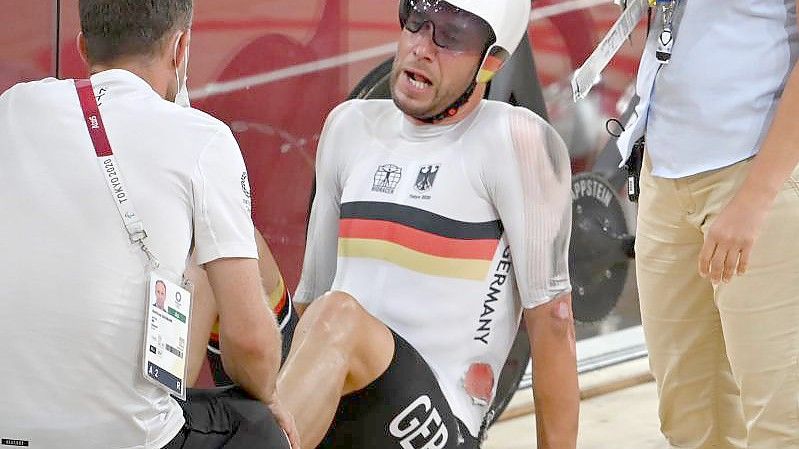 Roger Kluge sitzt nach einem Sturz im Izu Velodrome auf dem Boden. Foto: Sebastian Gollnow/dpa