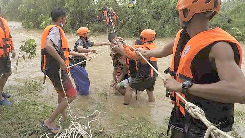 Rettungskräfte in Cagayan helfen während einer Evakuierung einem Kind. Foto: PHILIPPINE COAST GUARD/AP/dpa