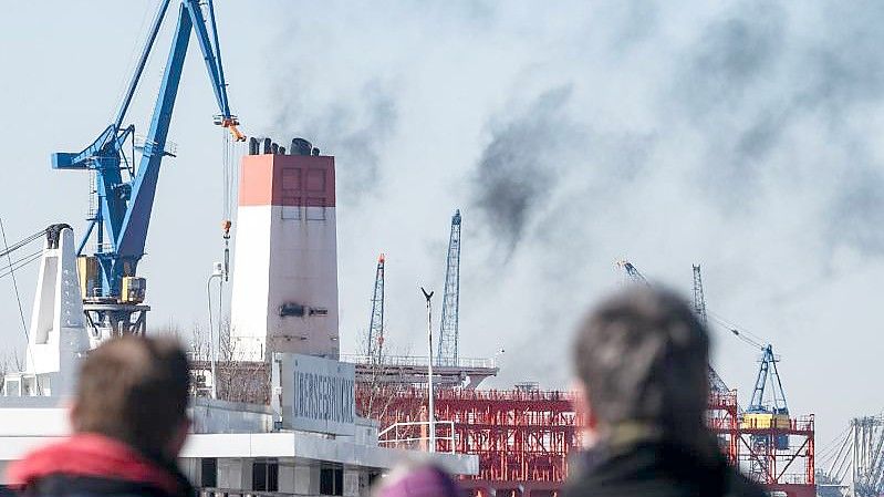 Abgase des Dieselantriebs entsteigen dem Schornstein eines Containerschiffes in Hamburg. Foto: Markus Scholz/dpa