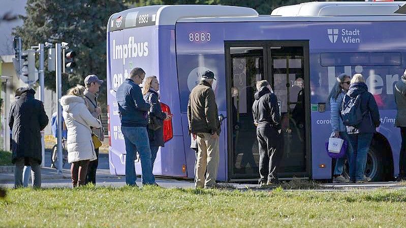 Impfwillige stehen vor einem Impfbus in Wien. Ab heute gilt die 2G-Regel für den gesamten Freizeitbereich. Foto: Herbert Neubauer/APA/dpa