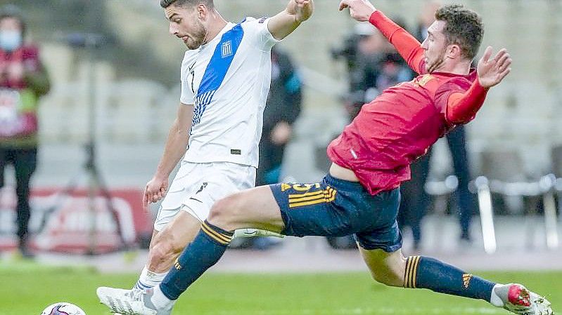 Griechenlands Giorgos Masouras (l) wird vom Spanier Aymeric Laporte attackiert. Foto: Thanassis Stavrakis/AP/dpa