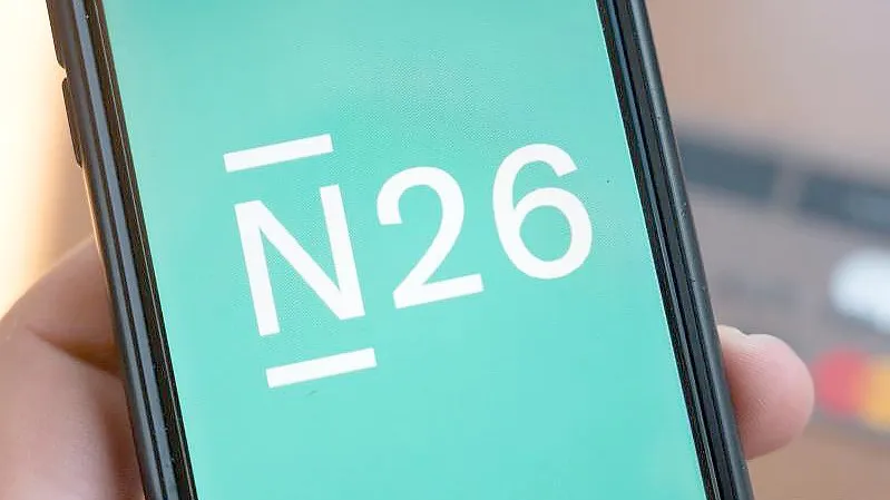 Das Logo der Smartphone-Bank N26 ist auf einem Smartphone eingeblendet. Foto: Christophe Gateau/dpa/Smybolbild