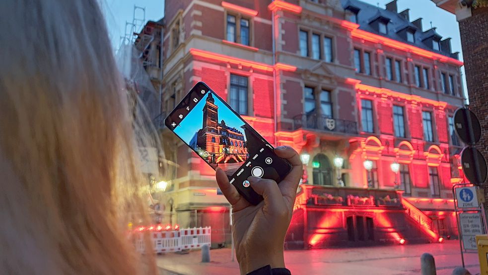 Vor einiger Zeit war das historische Rathaus in Leer in rotes Licht getaucht. Damals hatte die Veranstaltungsbranche auf ihre Situation aufmerksam gemacht. Am 25. November wird das Rathaus orange leuchten. Bild: Loger/Archiv