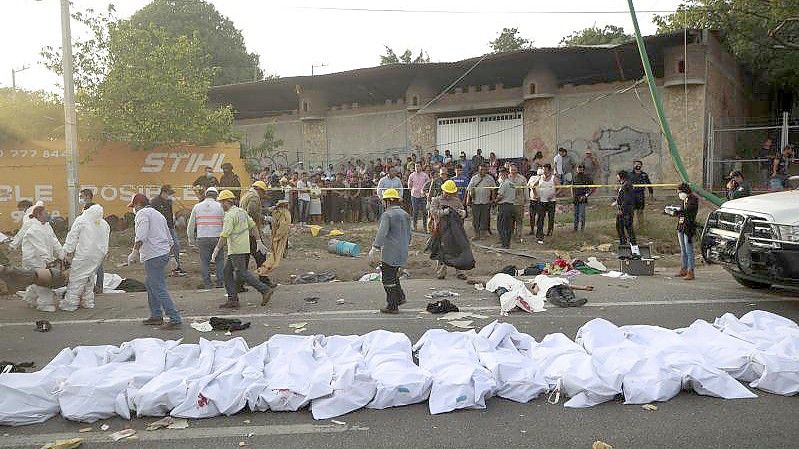 Leichen in Leichensäcken liegen nach einem Unfall in Tuxtla Gutierrez im mexikanischen Bundesstaat Chiapas am Straßenrand. Foto: Str/AP/dpa
