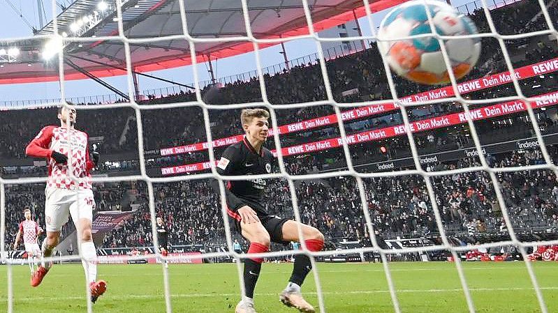 Frankfurts Jesper Lindström (r) erzielt das Tor zum 1:0. Der Mainzer Verteidiger Stefan Bell kann nicht mehr eingreifen. Foto: Arne Dedert/dpa