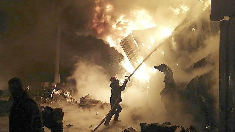 Flammen steigen aus den Containern in Latakia: Feuerwehrleute versuchen, das Feuer zu löschen. Foto: Uncredited/SANA/AP/dpa