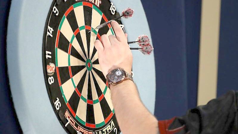 Ein Spieler holt bei der WM seine Darts vom Board. Foto: Bradley Collyer/PA Wire/dpa