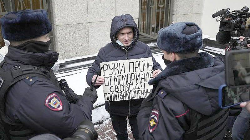 Ein Demonstrant im Beisein der Polizei, der Mitte Dezember in Moskau gegen die gerichtliche Verfügung protestiert. Foto: Pavel Golovkin/AP/dpa