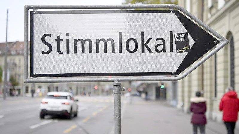 Eine Tafel weist auf ein Stimmlokal in Bern hin. Foto: Anthony Anex/KEYSTONE/dpa