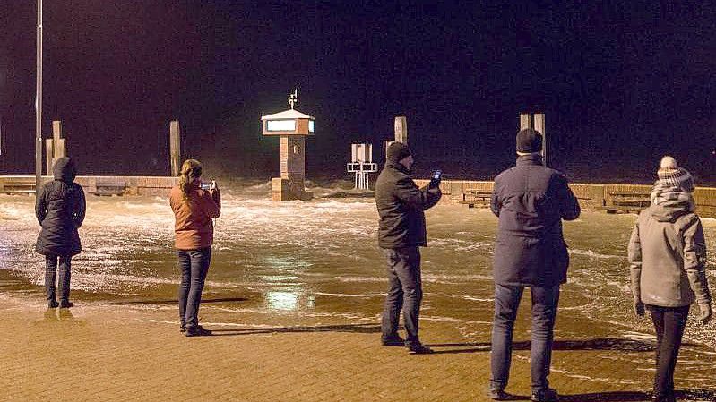 Eine Sturmflut überspült die Mole im Hafen von Norddeich in Ostfriesland. Foto: Lennart Stock/dpa