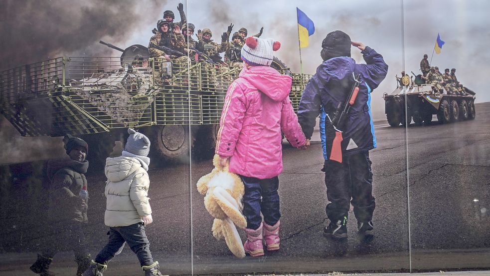 Sievierodonetsk in der Ukraine am Mittwoch: Kinder gehen an einem großformatigen Bild vorbei, aufgestellt im Gedenken an die ukrainischen Toten der Konfrontation zwischen dem ukrainischen Militär und den pro-russischen Separatisten. Foto: Ghirda/AP/DPA