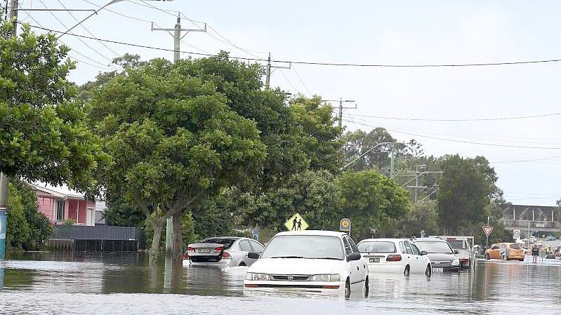 Viele Menschen versuchen vor den schnell steigenden Wassermassen zu fliehen. Foto: Jason O’brien/AAP/dpa