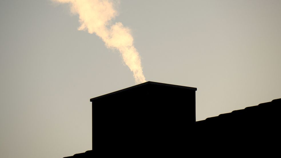 Rauch steigt aus dem Schornstein eines Mehrfamilienhauses auf. Wohnen verbraucht ungeheuer viel Energie, wie eine detaillierte Untersuchung in den Kreisen Wittmund und Friesland jetzt zeigt. Foto: Stratenschulte/dpa