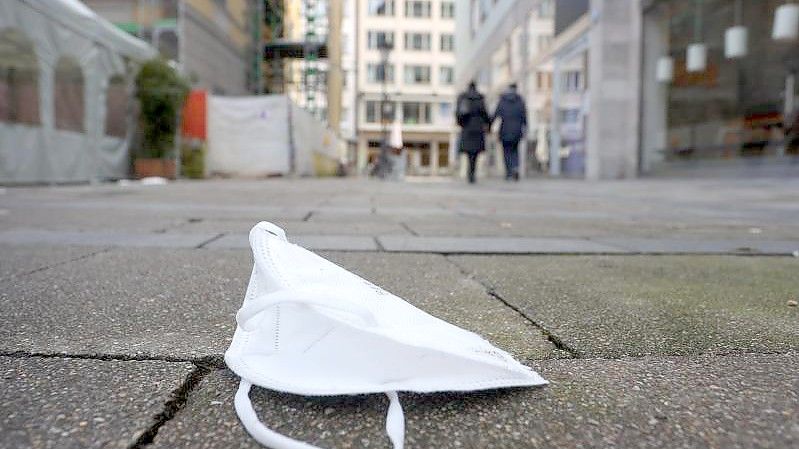 Eine FFP2 Maske liegt in der Münchner Innenstadt auf der Straße. Foto: Karl-Josef Hildenbrand/dpa