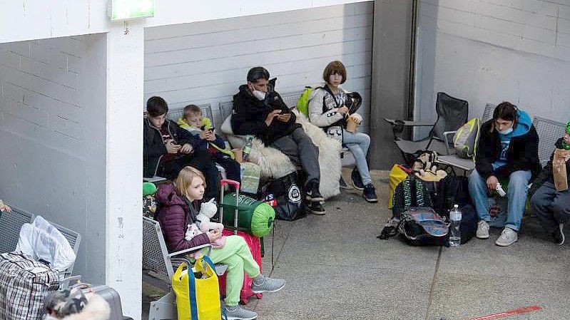 Flüchtlinge aus der Ukraine warten nach ihrer Ankunft am Hauptbahnhof in München. Foto: Sven Hoppe/dpa