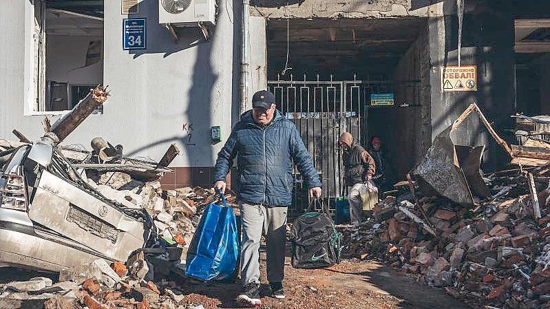 Kaum noch was übrig: Ein Mann trägt seine Habseligkeiten aus seinem zerstörten Haus in Charkow. Foto: Diego Herrera/XinHua/dpa