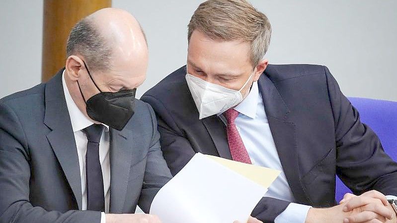 Finanzminister Christian Lindner (r, FDP) und Bundeskanzler Olaf Scholz (SPD) unterhalten sich im Bundestag. Foto: Kay Nietfeld/dpa