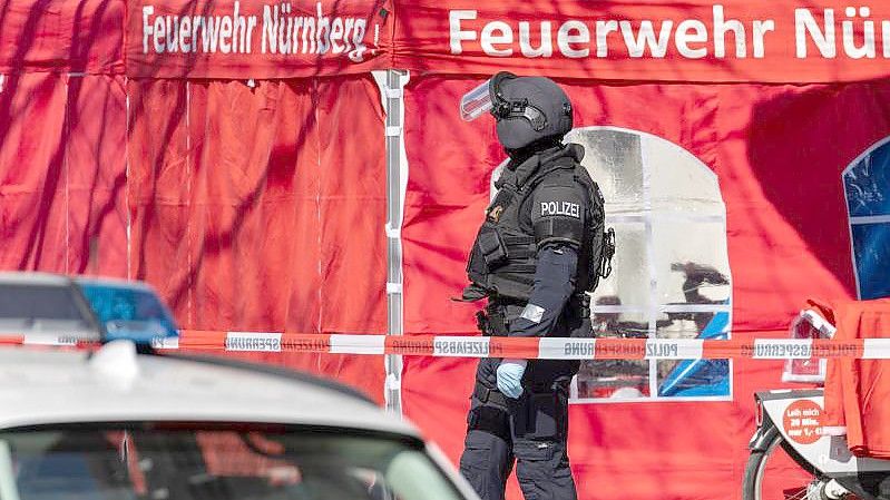 Ein Mitarbeiter der TSG München (Technische Sondergruppe), ein sogenannter „Entschärfer“, steht vor der Bank. Foto: Daniel Karmann/dpa