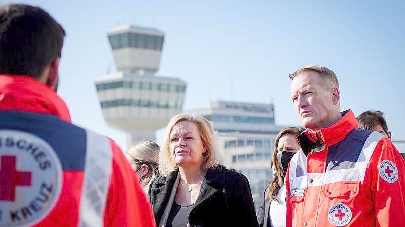 Bundesinnenministerin Nancy Faeser (SPD) und Christian Reuter, Generalsekretär des Deutschen Roten Kreuzes, besichtigen Notunterkünfte für Geflüchtete auf dem Gelände Berlin-Tegel. Foto: Kay Nietfeld/dpa