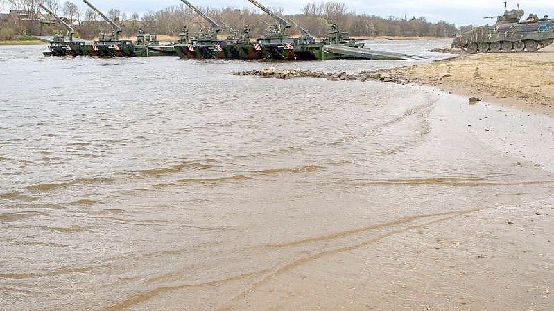 Ein Schützenpanzer vom Typ "Marder" fährt bei einer Bundeswehrübung am Elbestrand auf eine Schwimmschnellbrücke. Foto: Klaus-Dietmar Gabbert/dpa