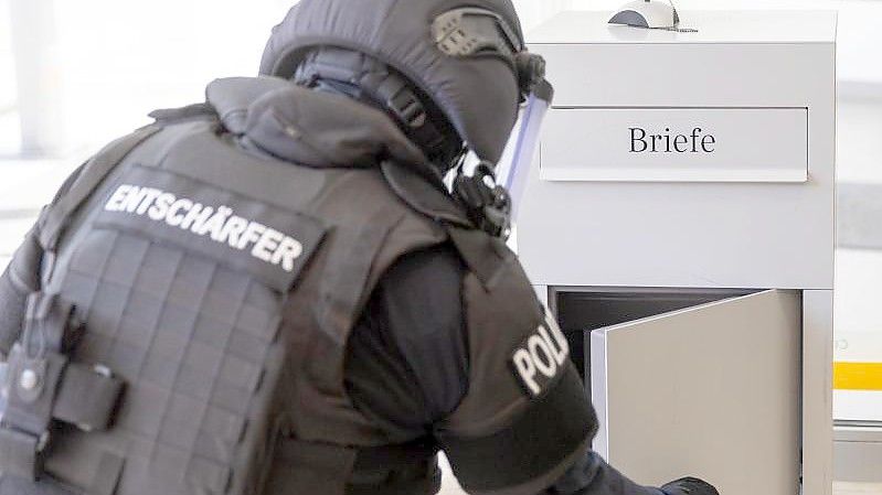 Ein Mitarbeiter der TSG München (Technische Sondergruppe) demonstriert, wie er den Briefkasten in einer Nürnberger Bank zuvor auf verdächtige Inhalte überprüft hatte. Foto: Daniel Karmann/dpa