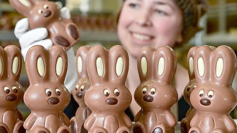 Angelina Piosik, Mitarbeiterin der Confiserie Felicitas GmbH in Hornow, zeigt per Hand gefertigte Osterhasen. Foto: Patrick Pleul/dpa-Zentralbild/dpa