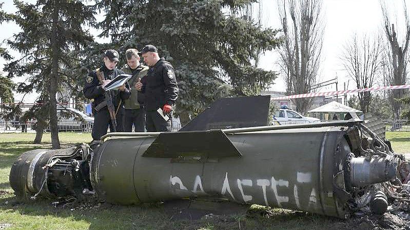 Ukrainische Soldaten während Ermittlungsarbeiten neben einem Fragment einer Tochka-U-Rakete mit der russischen Aufschrift „Für Kinder“ nahe des Bahnhofs in Kramatorsk. Foto: Andriy Andriyenko/AP/dpa