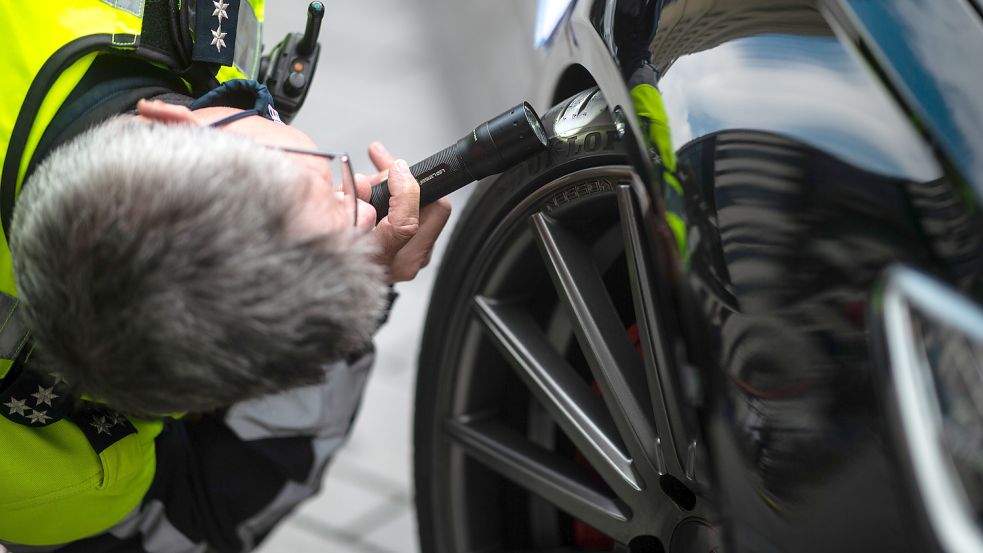 Ein Polizist überprüft das Fahrzeugprofil eines Sportwagens. Ähnlich wie auf diesem Foto aus Düsseldorf wurden auch in Leer Autos kontrolliert. Foto: Güttler/dpa