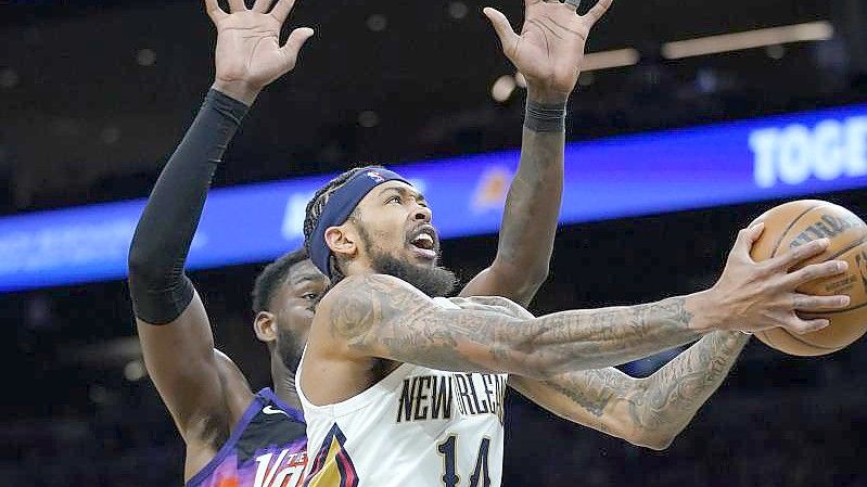 Deandre Ayton (l) von den Phoenix Suns versucht Brandon Ingram von den New Orleans Pelicans zu blocken. Foto: Matt York/AP/dpa