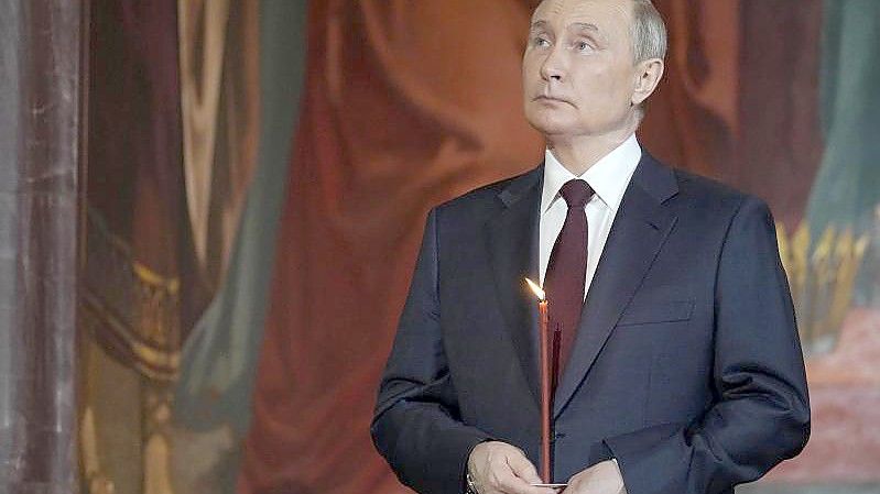 Präsident von Russland Wladimir Putin besucht den orthodoxen Ostergottesdienst in der Christ-Erlöser-Kathedrale in Moskau und hält eine Kerze. Foto: Alexander Zemlianichenko/Pool AP/dpa