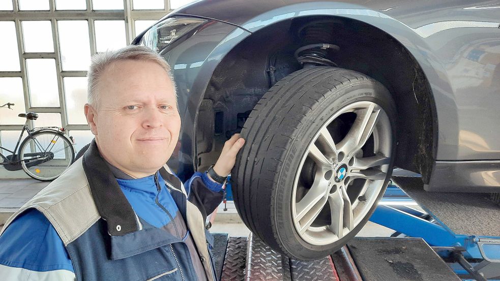 Jörg Luikenga, Leiter der Leeraner Tüv-Station, vor einem deutlich abgefahrenen Reifen. Foto: Kierstein