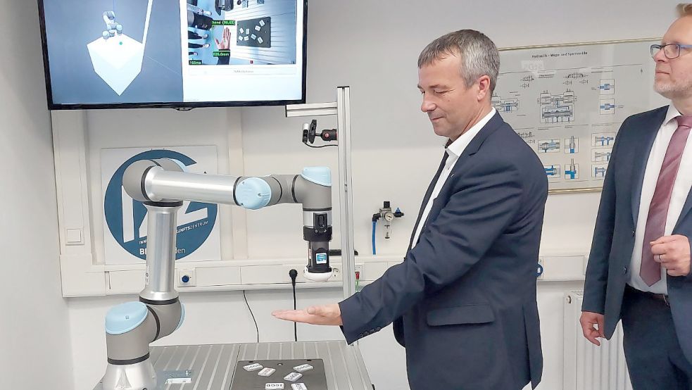 SPD-Bundestagsabgeordneter Johann Saathoff probierte die Roboter-Mensch-Kollaboration aus. Die Maschine, die die Form seiner Hand abgespeichert hat, reichte ihm ein Objekt und folgte der Hand, wenn sich diese bewegte. Foto: Hanssen