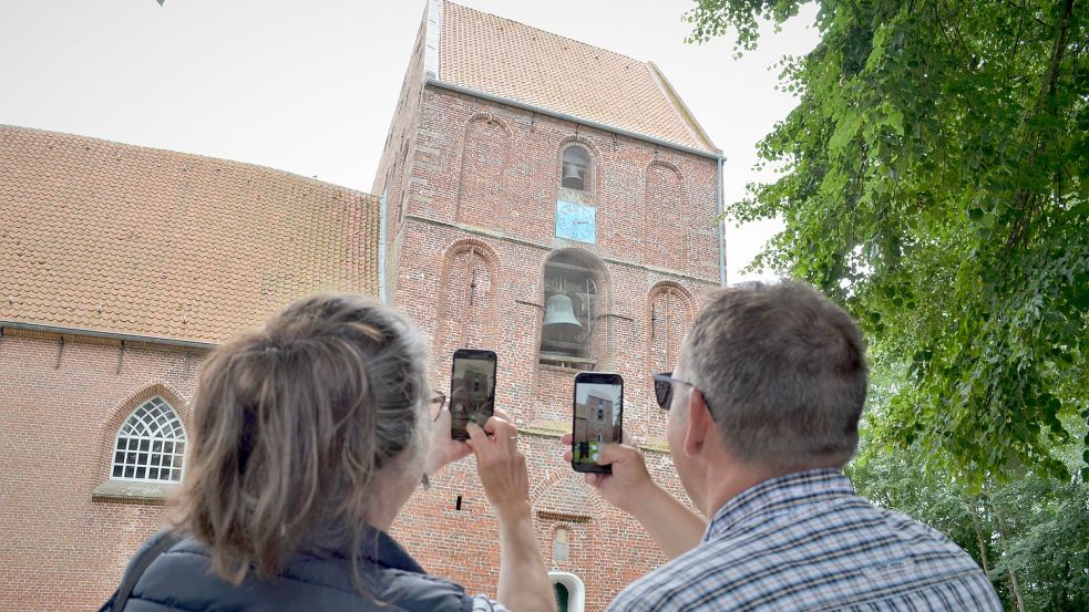 Ein Ehepaar ist aus dem Kreis Viersen am Niederrhein nach Ostfriesland gereist, um den schiefsten Turm der Welt zu fotografieren. Foto: Hoppe