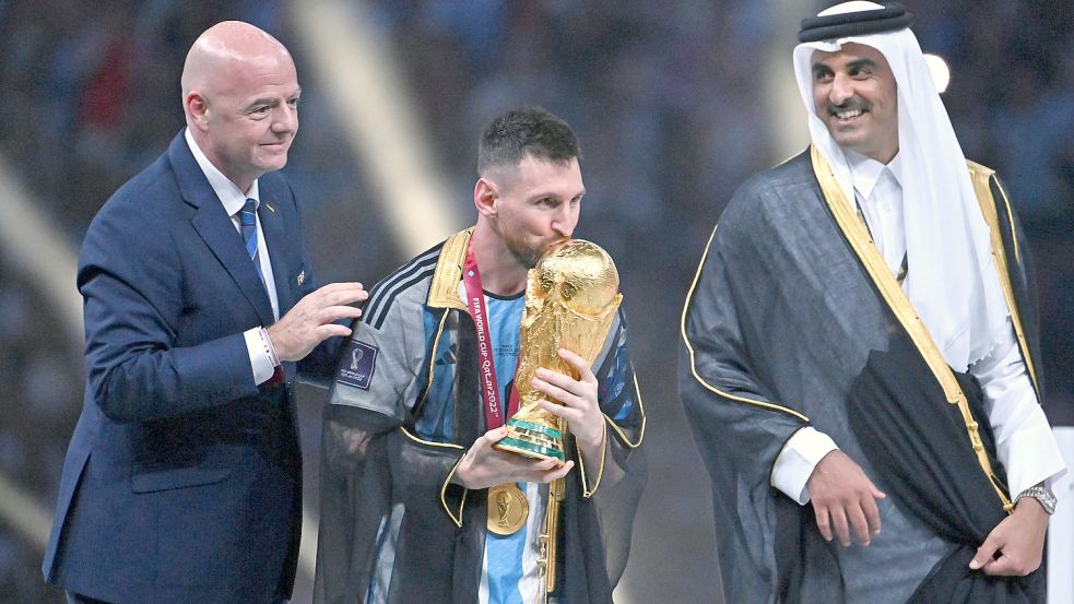 Lionel Messi küsst den WM-Pokal und trägt den ortstypischen Bischt-Umhang. Foto: imago-images/Sven Simom