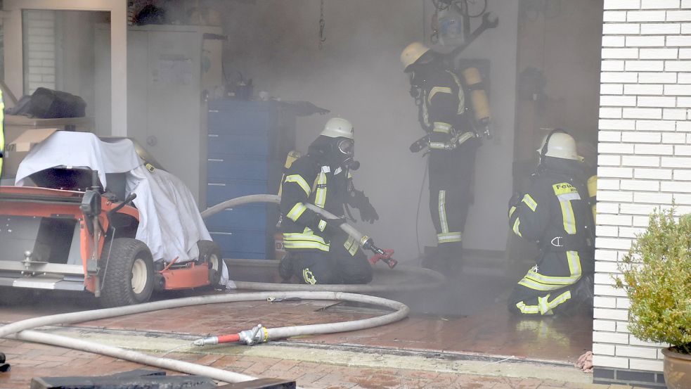 Unter Atemschutz gingen die Einsatzkräfte gegen das Feuer in einer Werkstattgrube in einer Garage vor. Foto: Ammermann