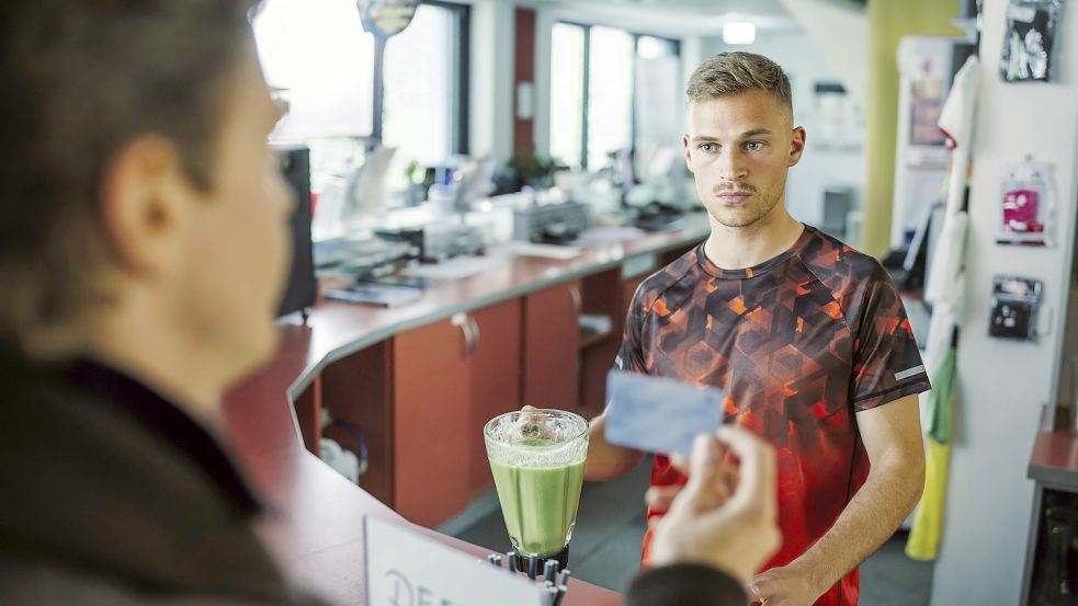 Als Fitnesstrainer Kenny beantwortet Joshua Kimmich Fragen des Assistenten Kalli Hammerann (Ferdinand Hofer). Foto: BR/Tellux Film GmbH/Hendrik Heiden