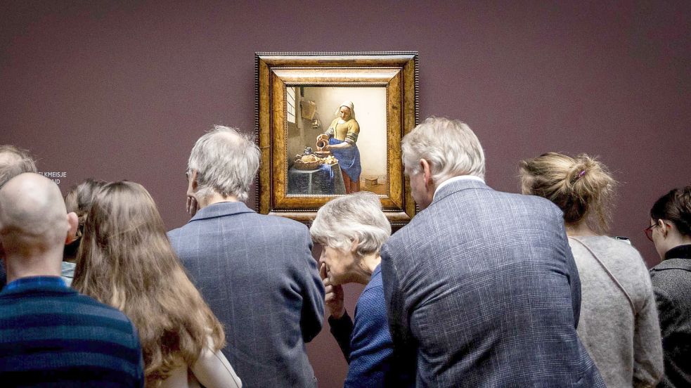 Zahlreiche Besucher stehen im Rijksmuseum vor dem Gemälde „Die Milchmagd“ von Johannes Vermeer. Nur drei Tage nach Eröffnung ist die große Vermeer-Ausstellung ausverkauft. Foto: ANP