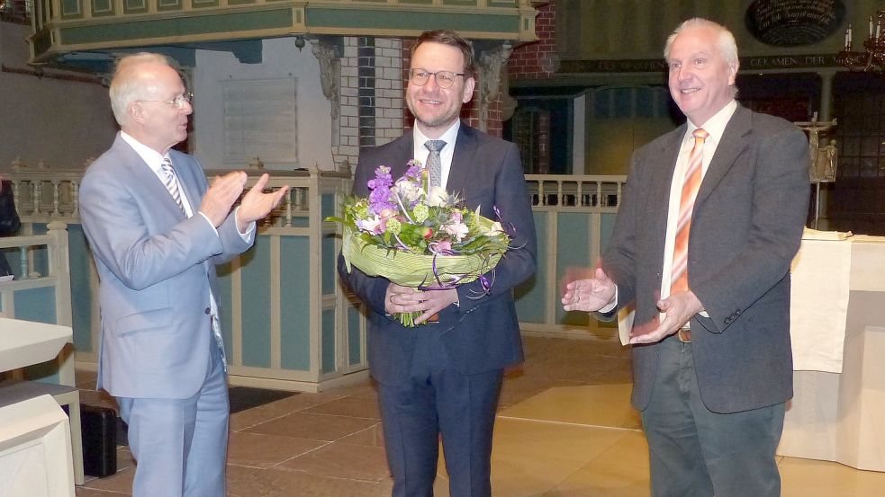 Regionalbischof Dr. Detlef Klahr (links) und der Vorsitzende der Kirchenkreissynode und des Wahlausschuss, Theo Weber (rechts), gratulierten Pastor Christian Neumann in der Ludgeri-Kirche Norden zur Wahl als Superintendent des Kirchenkreises Norden. Foto: Marika Cuno