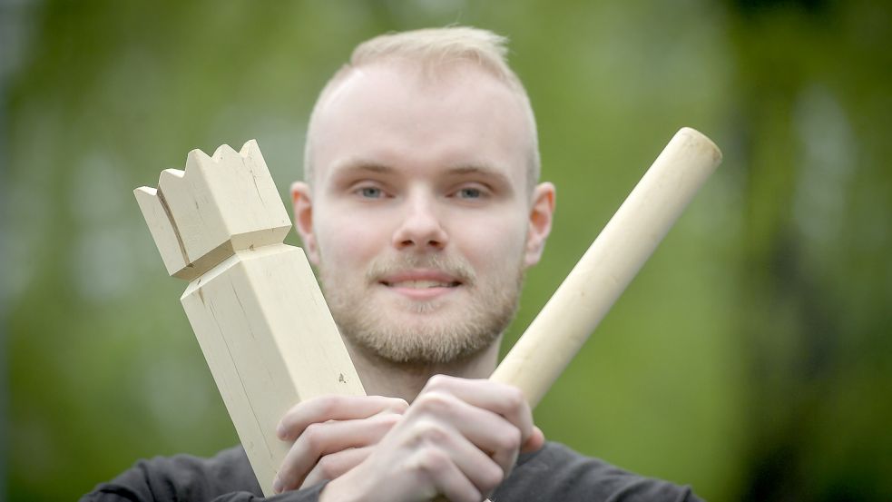 Wikingerschach ist ein beliebtes Outdoor-Spiel. Volontär Lars Löschen hält den wichtigen König und einen Wurfstab in der Hand. Foto: Ortgies