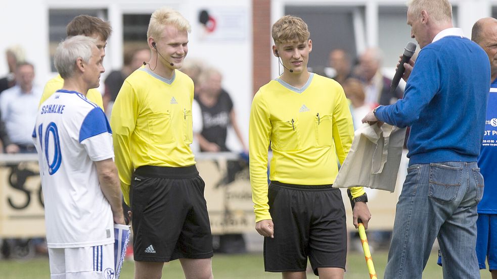 Beim Duell zweier Traditionsteams in Borssum stand urplötzlich Spielleiter Enno Träger (Dritter von links, blonde Haare) im Mittelpunkt. Er wurde von Peter Bartsch (rechts) geehrt. Auch Schalke-Legende Olaf Thon (links) zeigte sich angetan vom Engagement des 20-Jährigen. Fotos: Doden