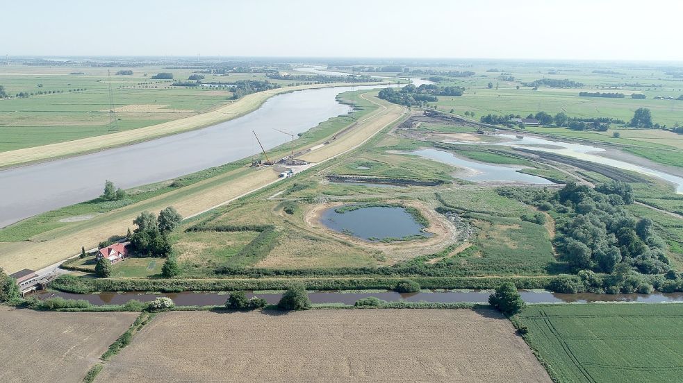 Blick auf den künftigen Tidepolder Coldemüntje in Westoverledingen. Oben links ist zu sehen, dass der Deich zur Ems hin geöffnet wurde. Dort entsteht ein Durchlassbauwerk, das künftig den Flut- und Ebbstrom auf die Polderfläche regeln soll. Foto: Bauunternehmen Ludwig Freitag.