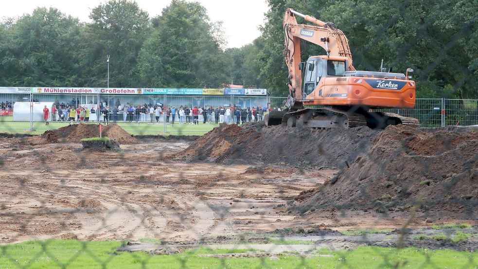Der Bagger an der Baustelle des neuen Kunstrasenplatzes hat den besten Blick auf das Freundschaftsspiel des SV Großefehn gegen Kickers Emden. Foto: Böning
